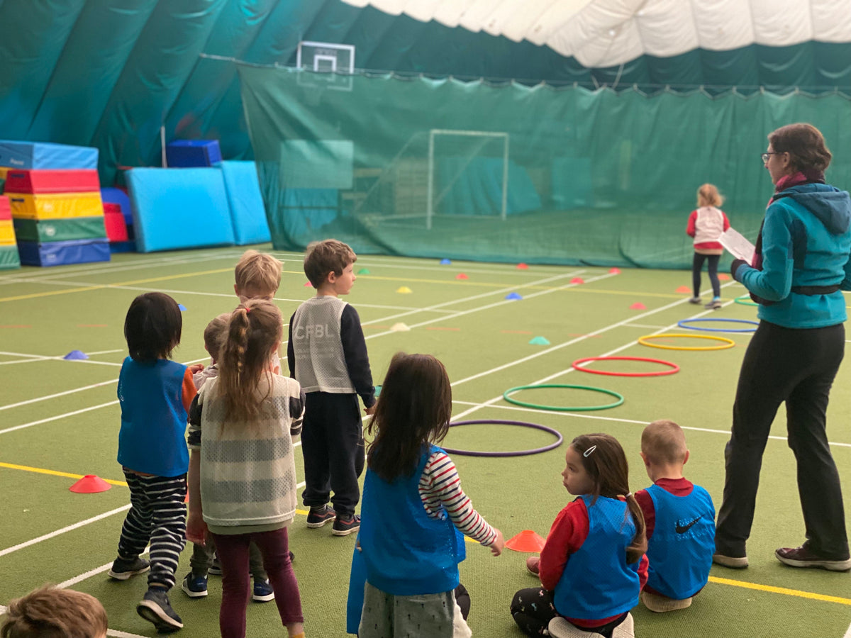 Enfants et coach HOLICAMP devant une structure gonflable lors d'une animation en salle