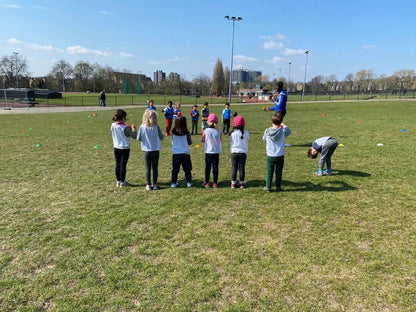 Groupe d'enfants alignés sur l'herbe avant un jeu HOLICAMP en plein air